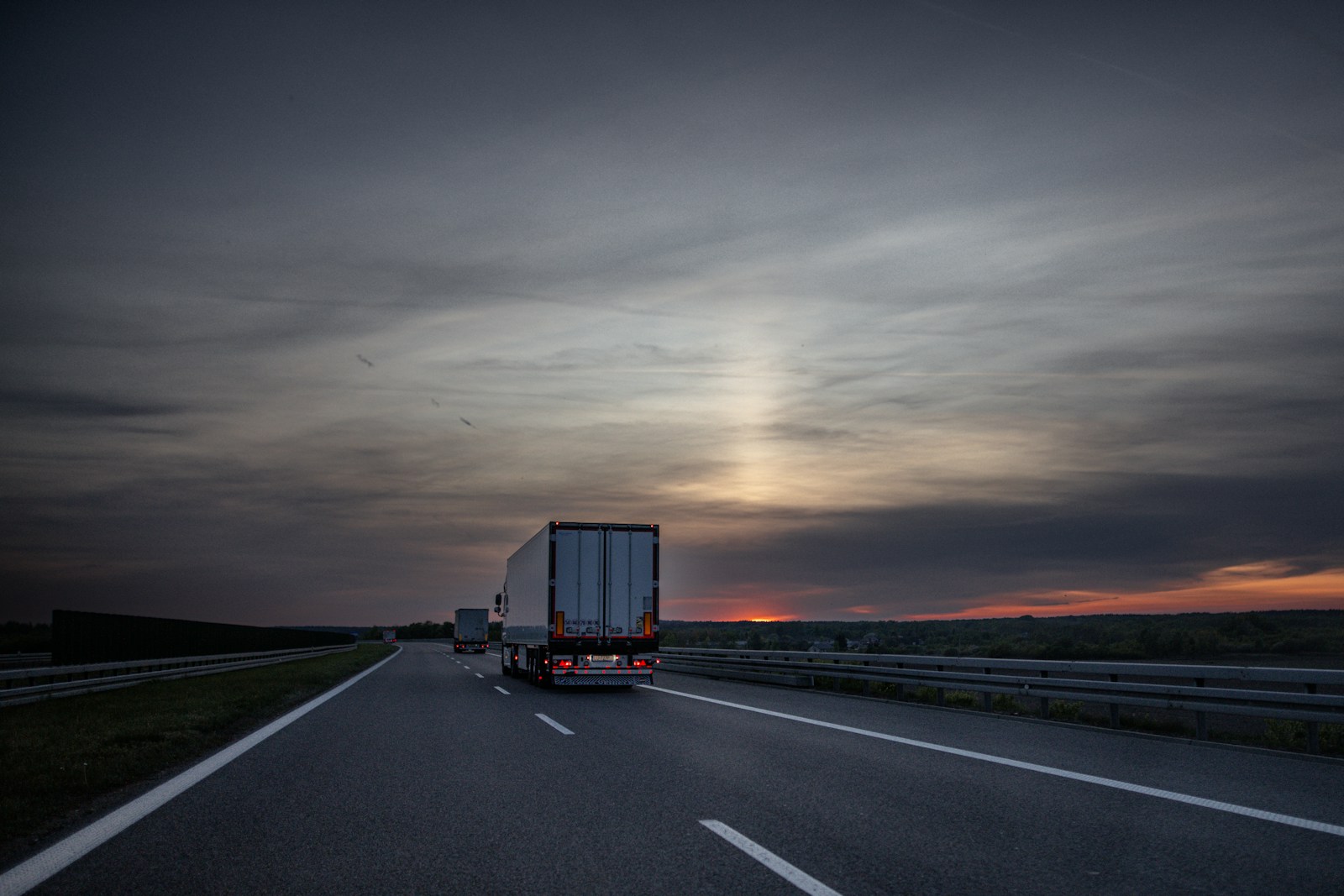 Vogntog på motorvei i solnedgang